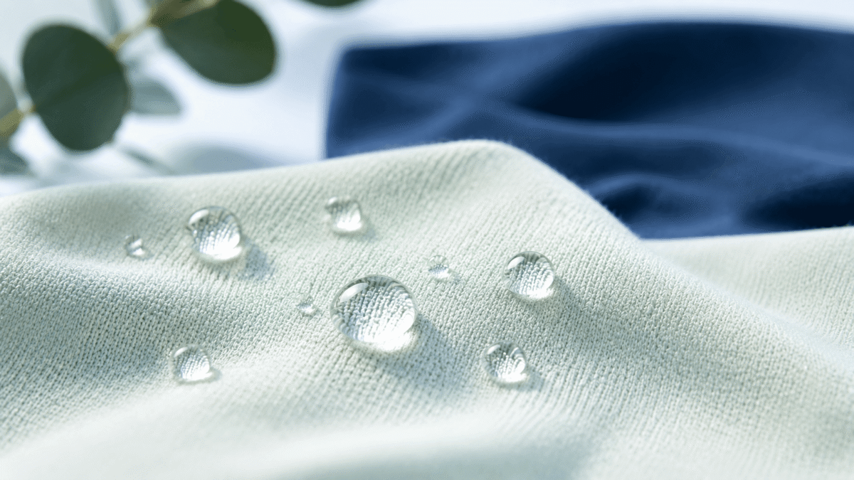 PFAS-free water repellent — water beading on soft light-colored apparel fabric